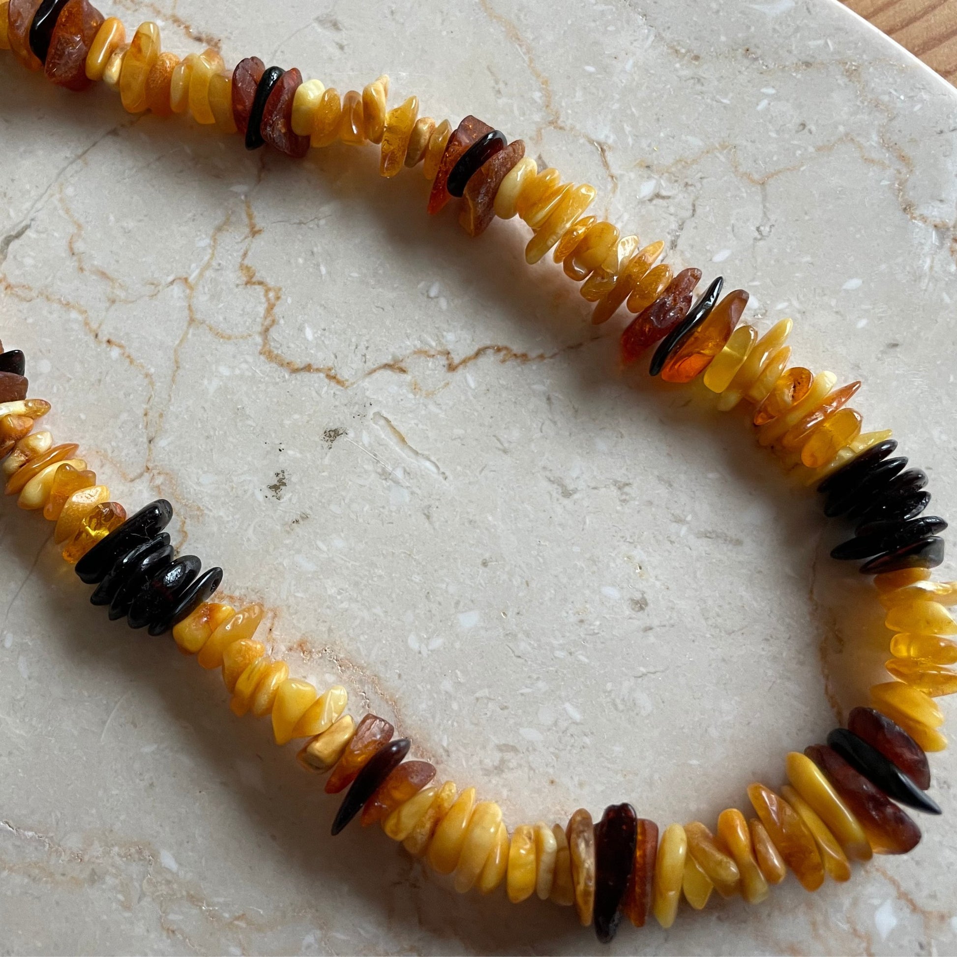 Natürliche Bernstein-Kette mit polierten Steinen in warmen Gelb-, Honig- und Cognac-Tönen, ideal für einen zeitlosen und eleganten Stil.