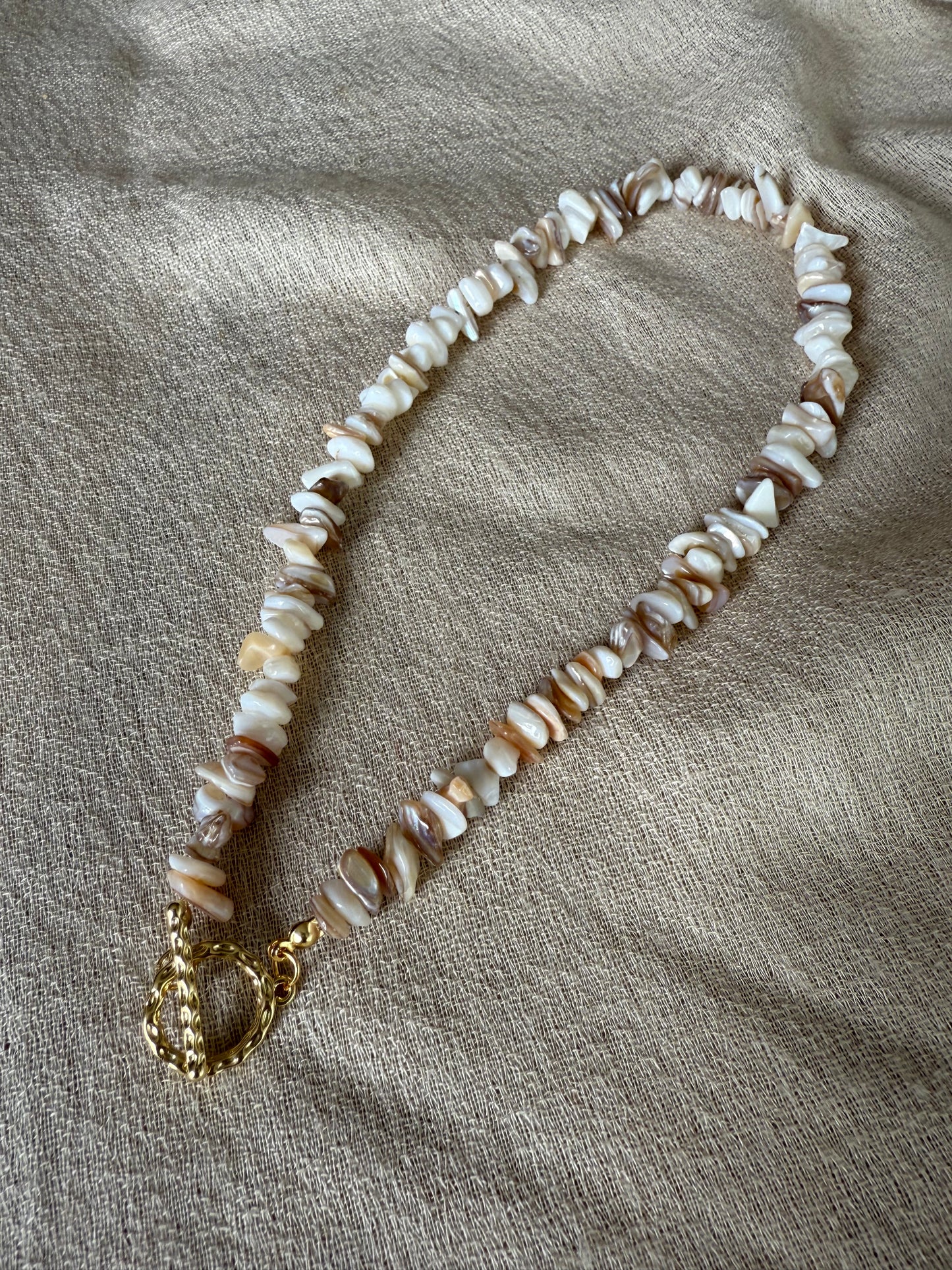 Natürlicher Schmuck mit echten Perlen auf hellem Leinentuch