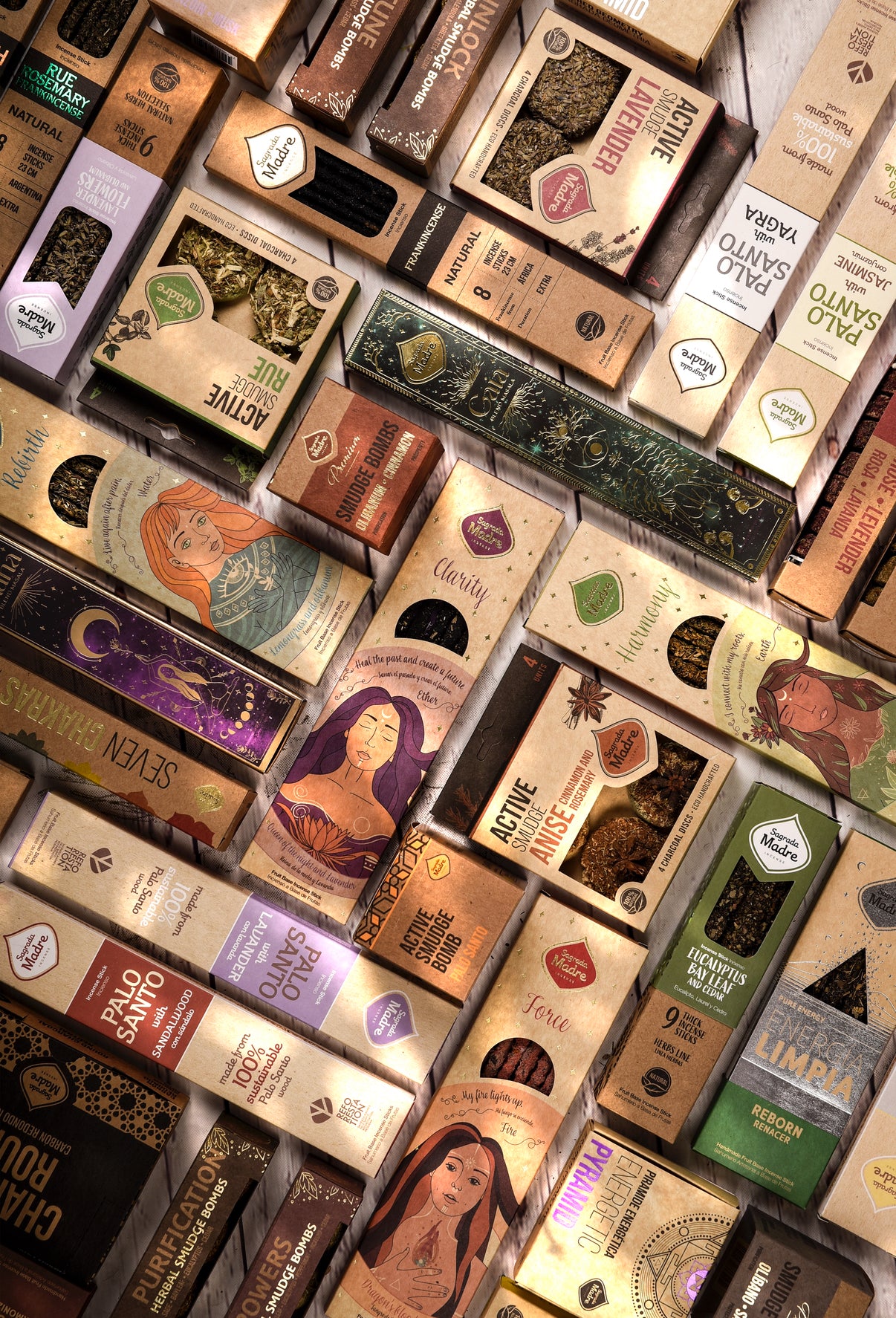 Sagrada Madre Räucherstäbchen in edler Verpackung mit goldenen und erdigen Details, fotografiert zwischen Kräutern, Rauch und Ritualobjekten. Symbol für handgefertigte, natürliche Räucherwerke aus Argentinien – in Kooperation mit ARUNĀ ALCHEMY.