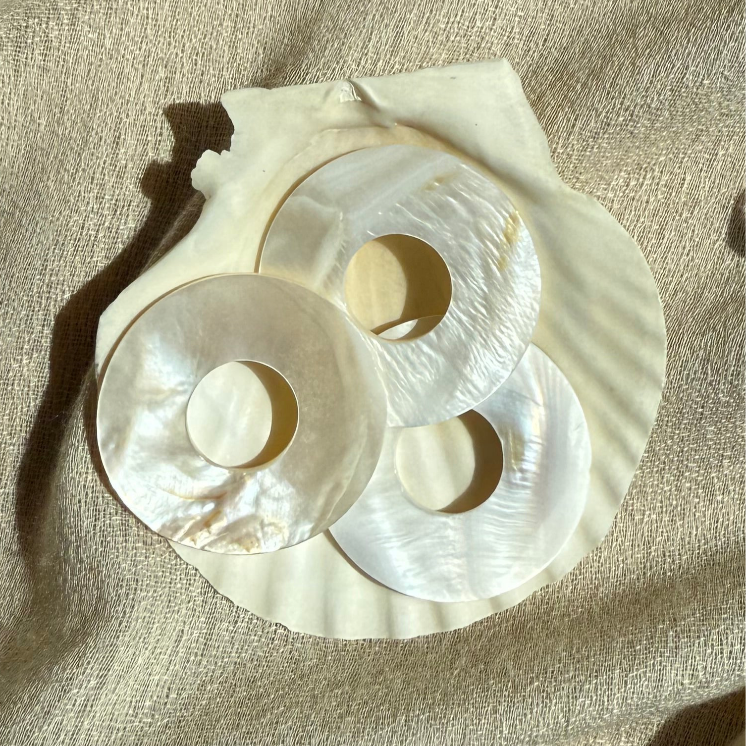 Kreisförmiger Perlmutt Anhänger mit schimmernder Oberfläche . Nahaufnahme.